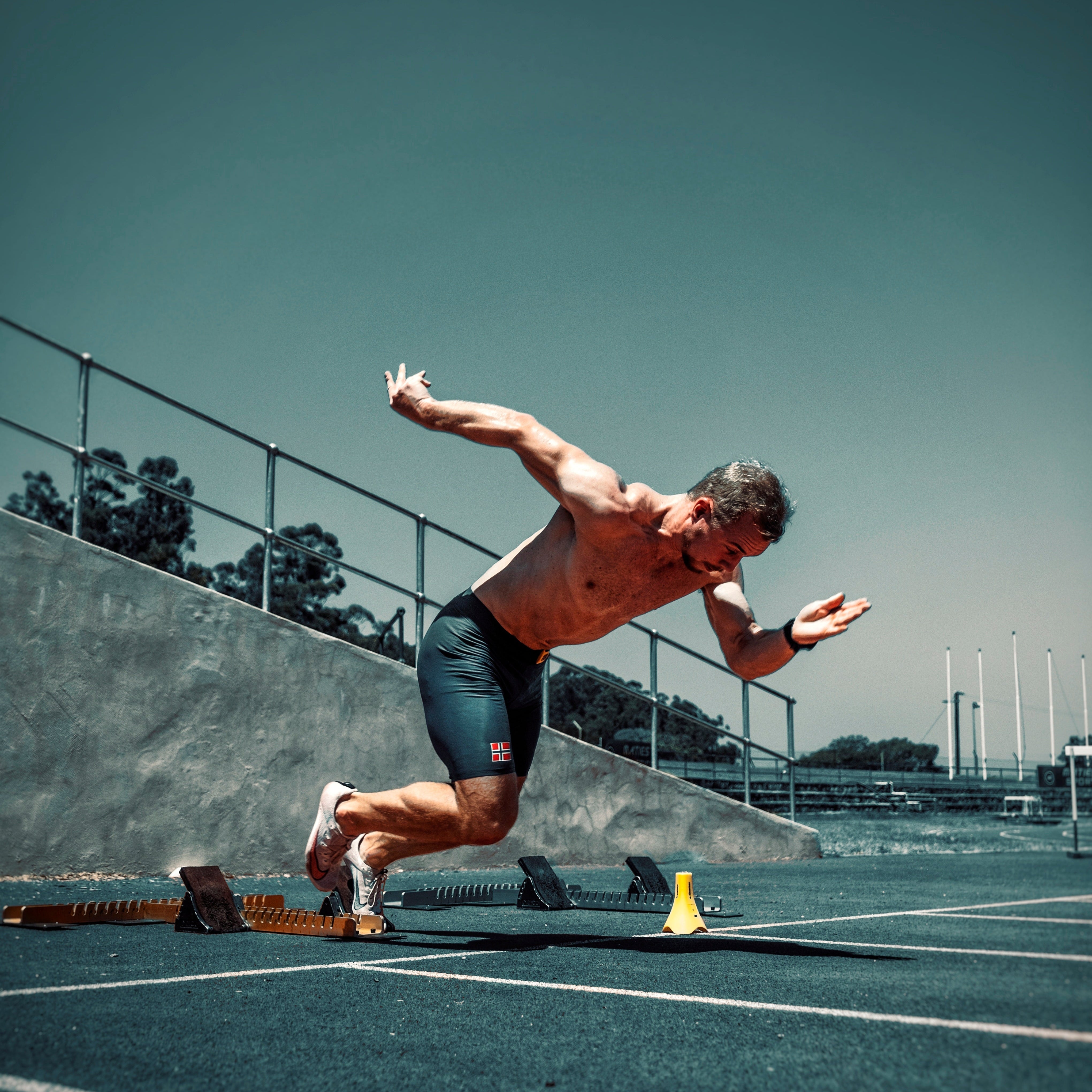 Sprinter exploding out of starting blocks on a track during a speed training session